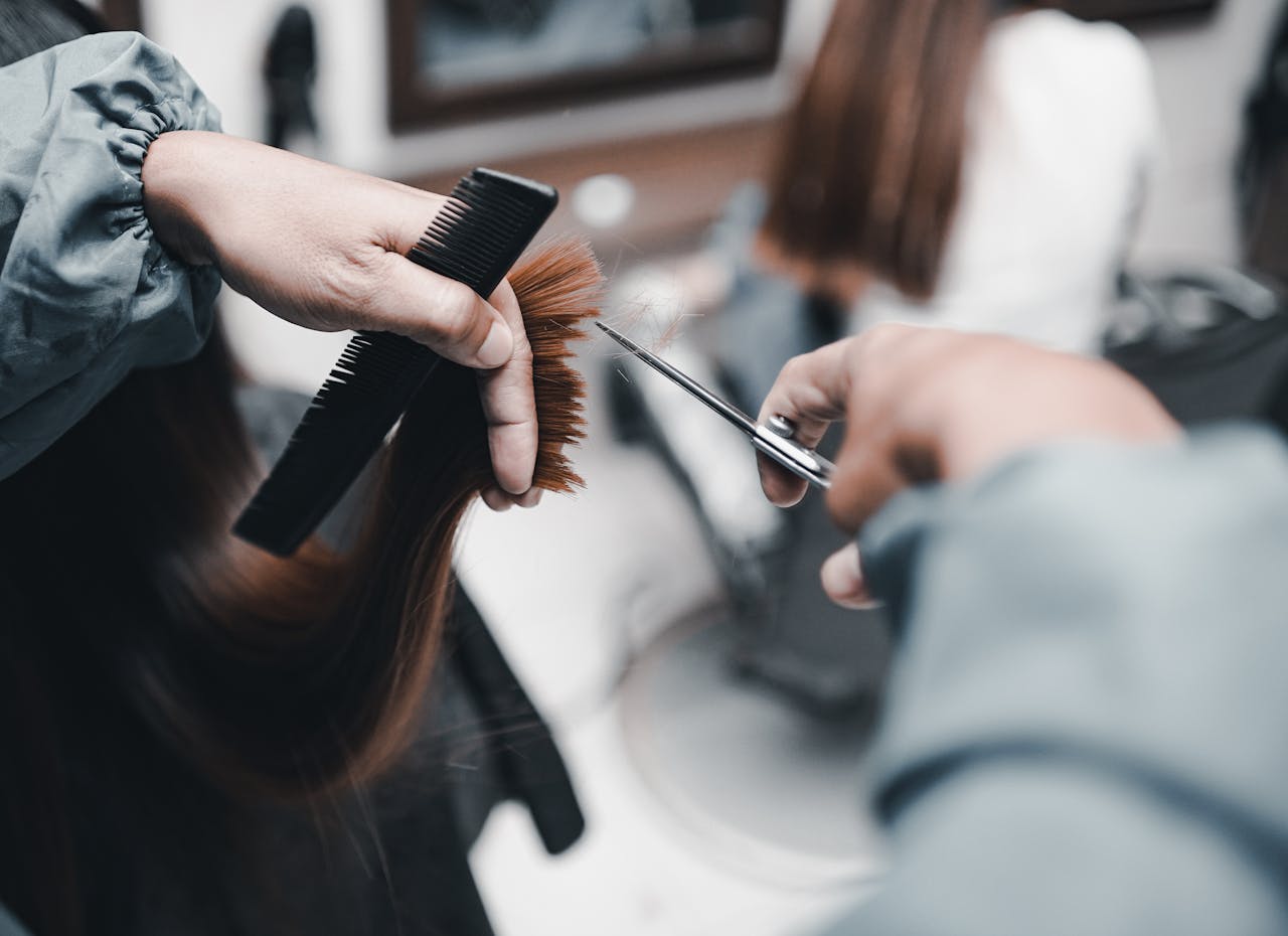 A woman is cutting her hair with scissors